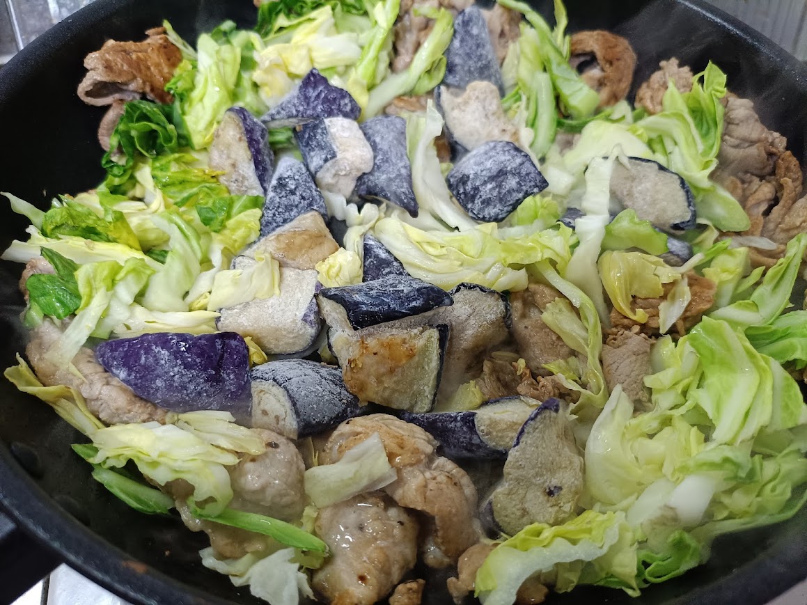 揚げなす・豚肉・キャベツを炒めている様子
