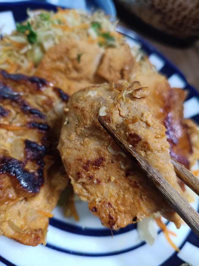 焼いた豚ロースみそ漬けを箸でつまむ実食写真