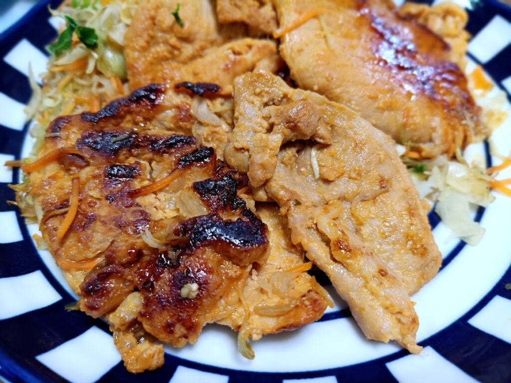 焼き上がった豚ロースみそ漬けをキャベツと盛り付けた様子