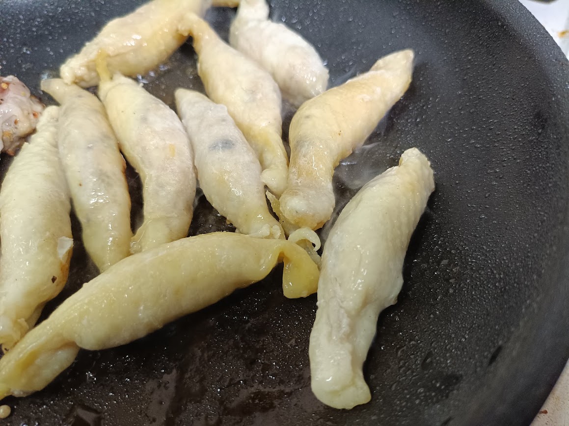 業務スーパー鶏皮ぎょうざを油を敷かずにフライパンで焼いている様子