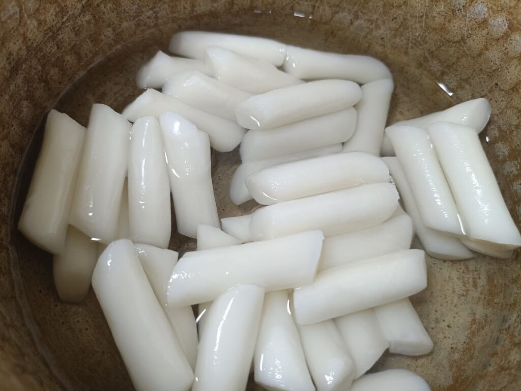 冷凍トッポッキを開封して餅を鍋に入れて調理している画像
