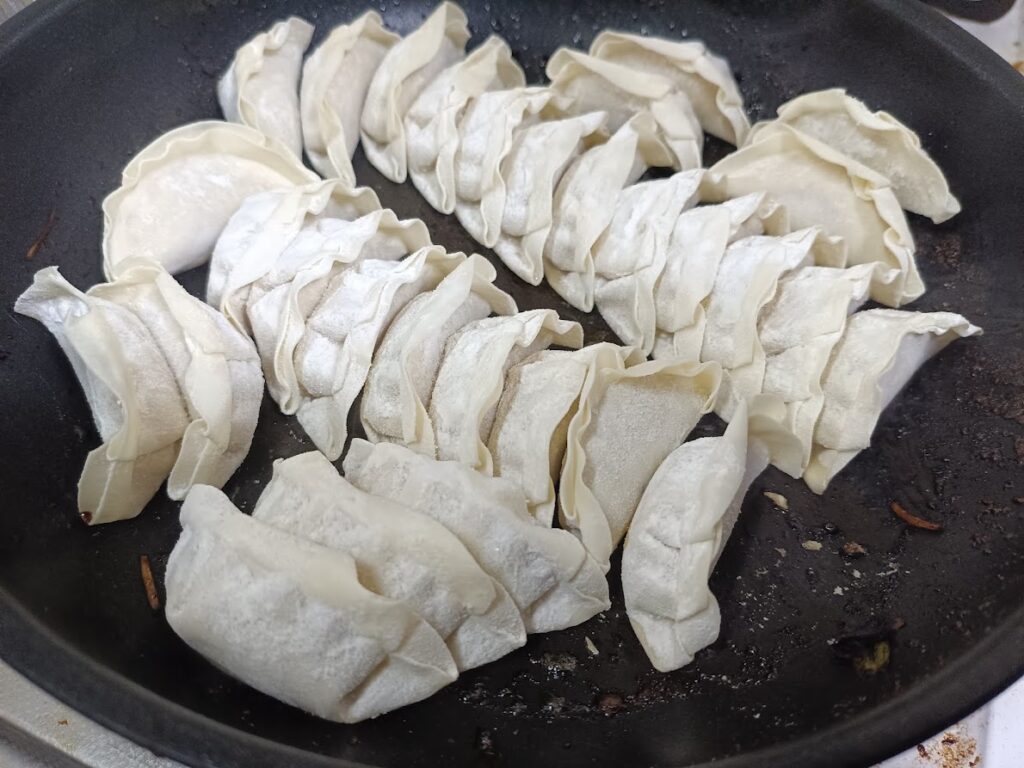 宇都宮みんみん餃子をフライパンで焼いている様子