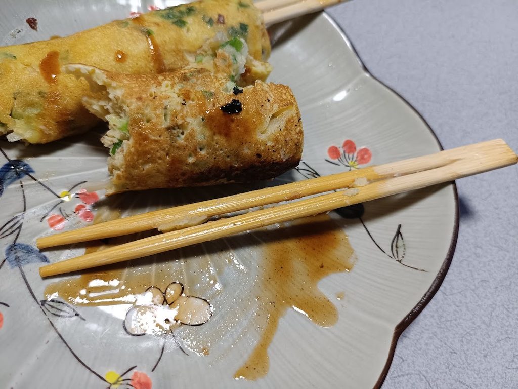 はし巻きを箸で食べかけている様子