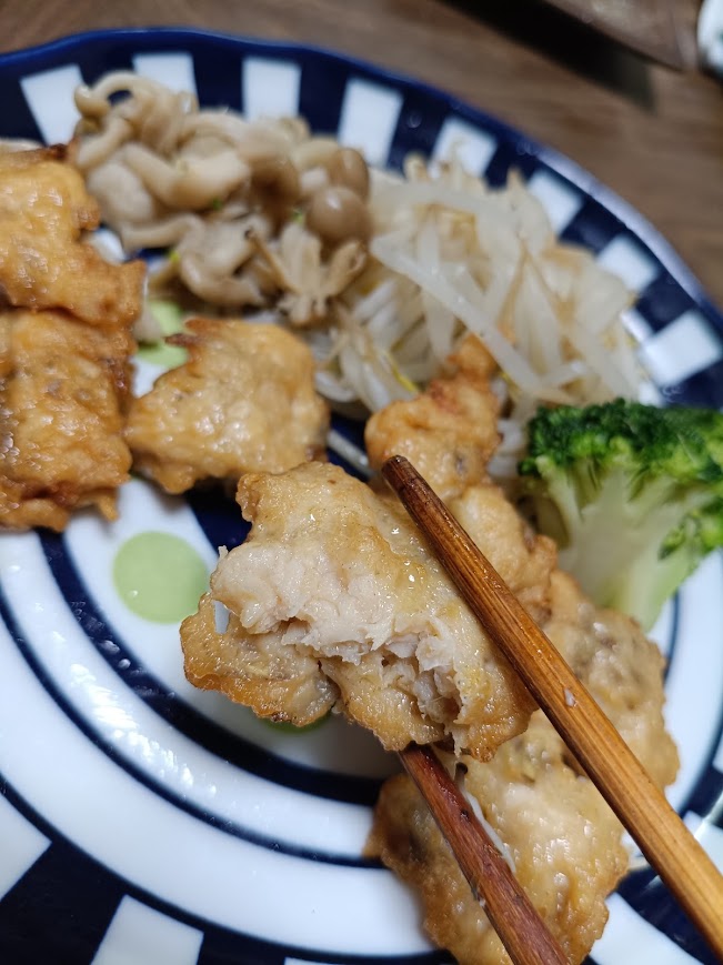 箸でつまんだ肉のハナマサ鶏とごぼうのから揚げの断面