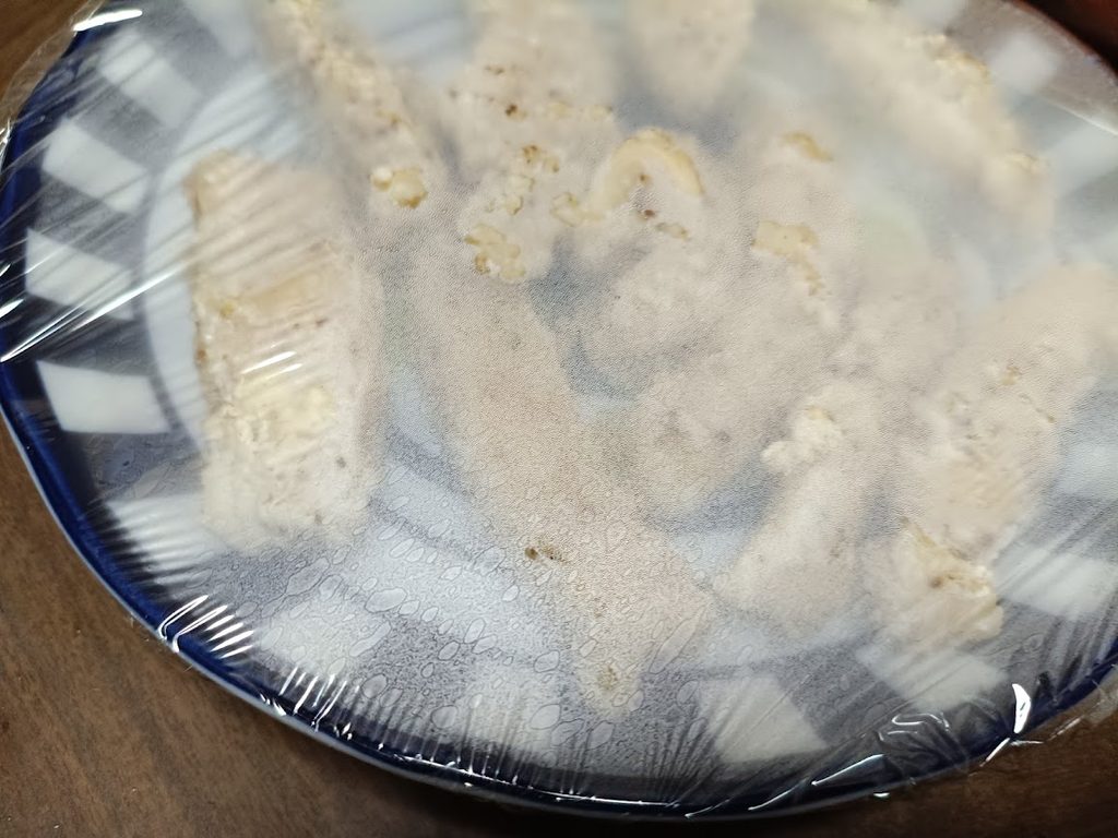 ラップをかけた電子レンジ加熱前のスパイシーチキンスティック