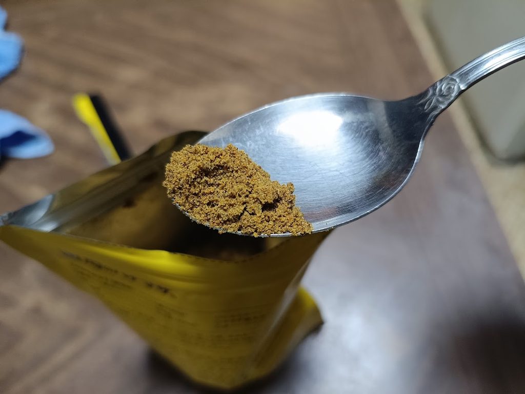 スプーンにすくった黒カレーの粉末