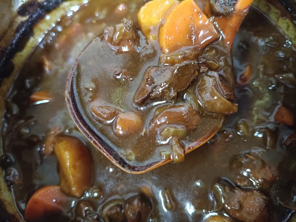 黒カレーを鍋で調理している様子