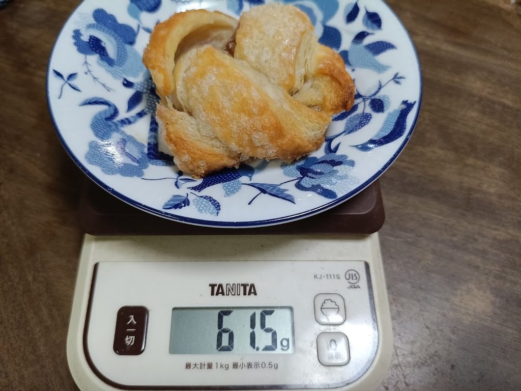 ミニアップルキャラメルシュトルーデル1個をキッチンスケールで計量した様子(61.5g・5個計測した中の代表例)