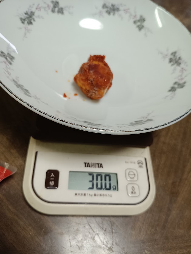 甘辛ヤンニョムチキン1個をはかりで計量している様子(30.0g)
