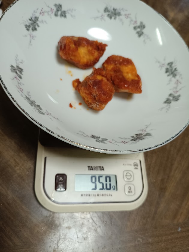 甘辛ヤンニョムチキン3個をはかりで計量している様子(95.0g)