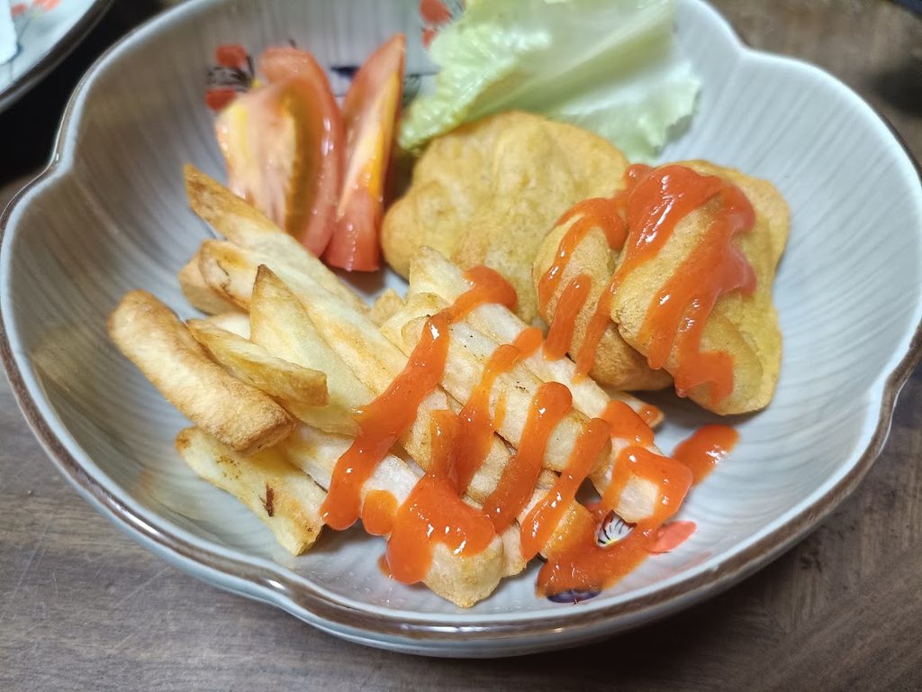 シラチャーソースをかけたフライドポテトとナゲット