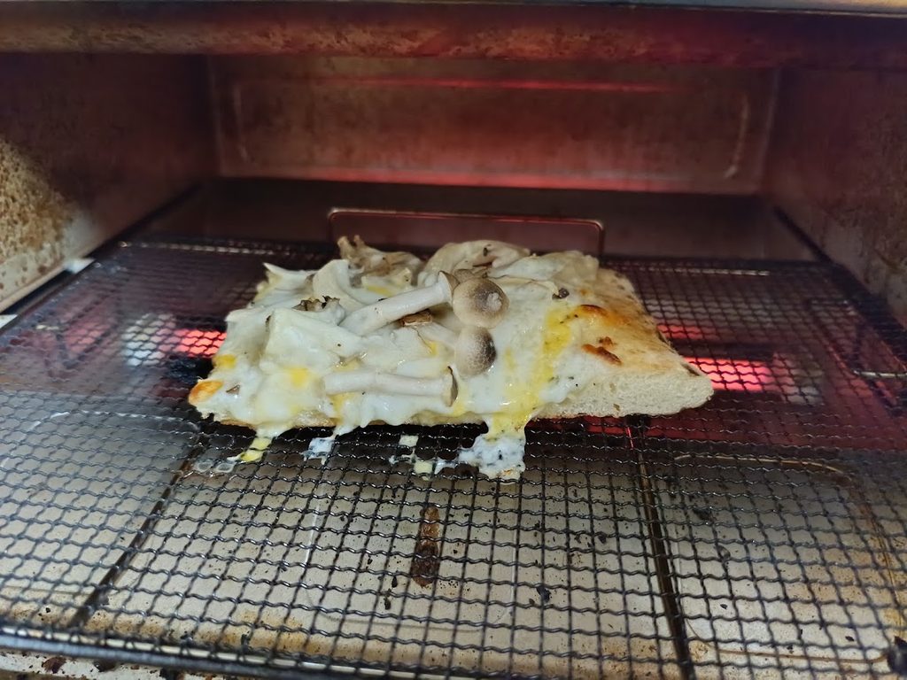 トースターの中でチーズが溶けたきのこづくしピザ