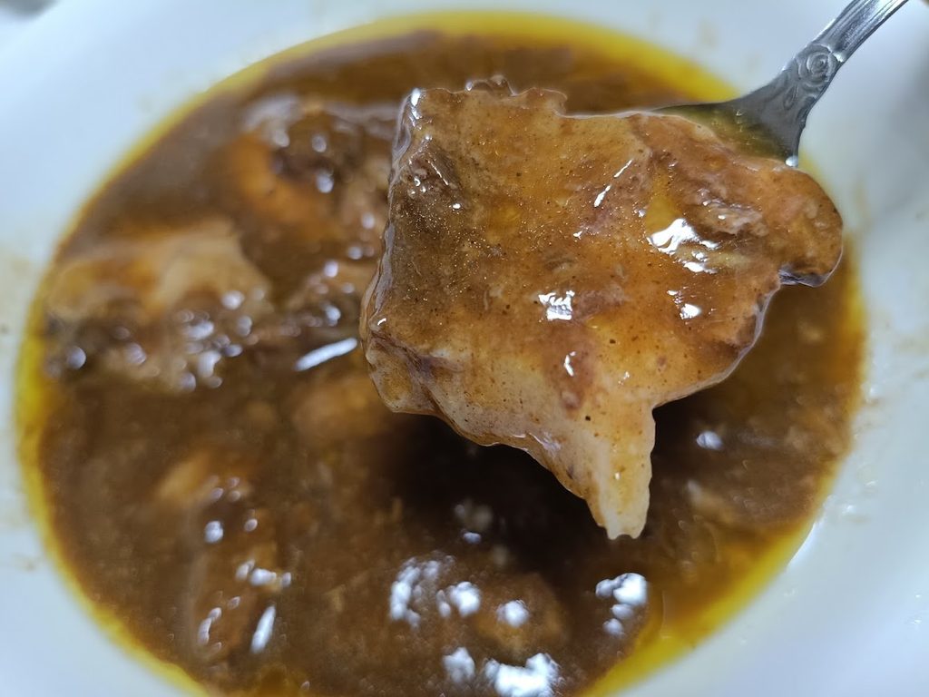 スプーンにのせた豚の角煮(カレーがからんでいる)