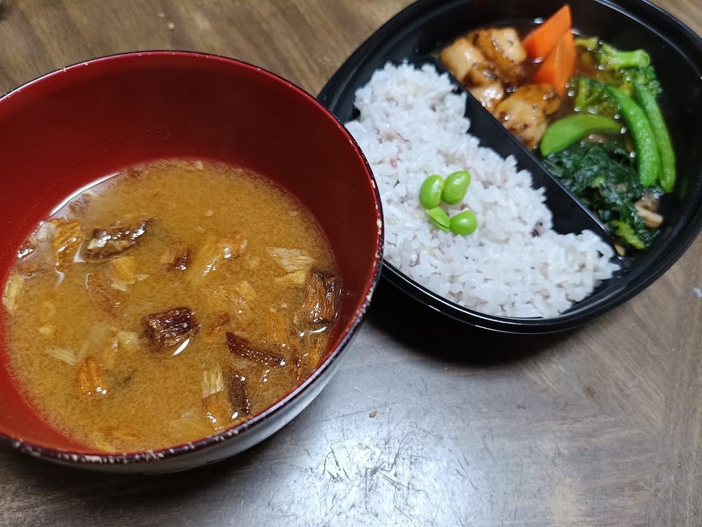 お弁当と、赤い椀に入れたお味噌汁