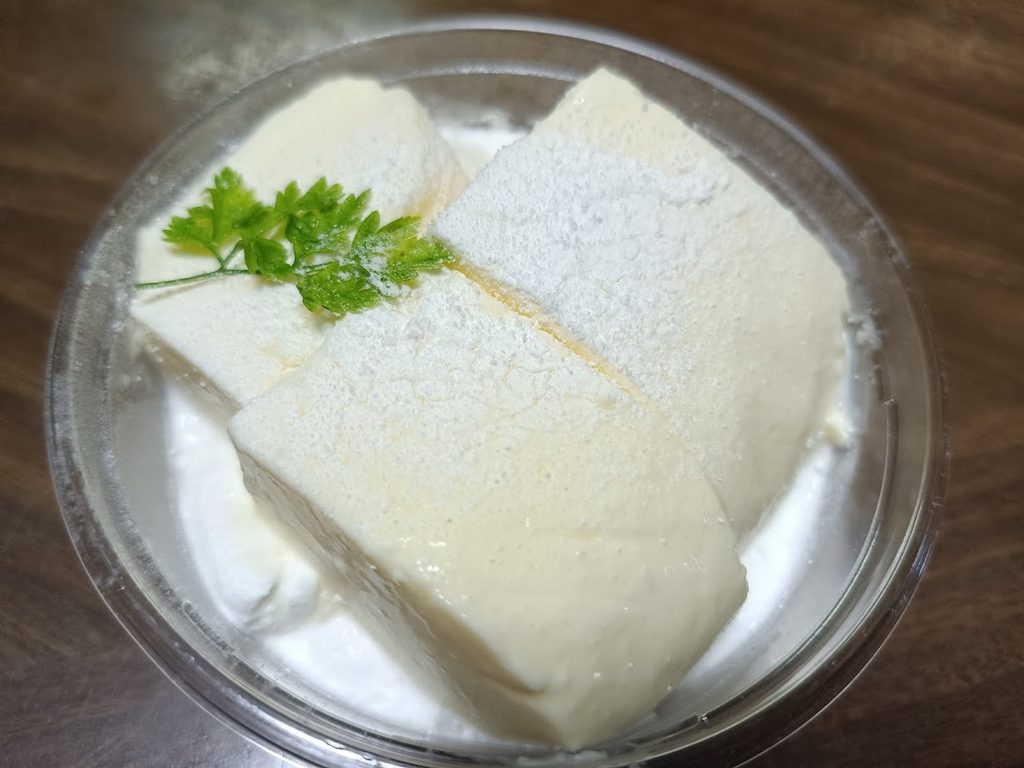 蓋を開けた雪どけレアチーズ（上に白い粉と緑の飾り）