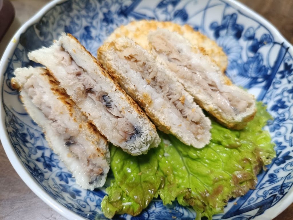 レタスを敷いた皿の上の、切った断面が見えるまぐろカツ
