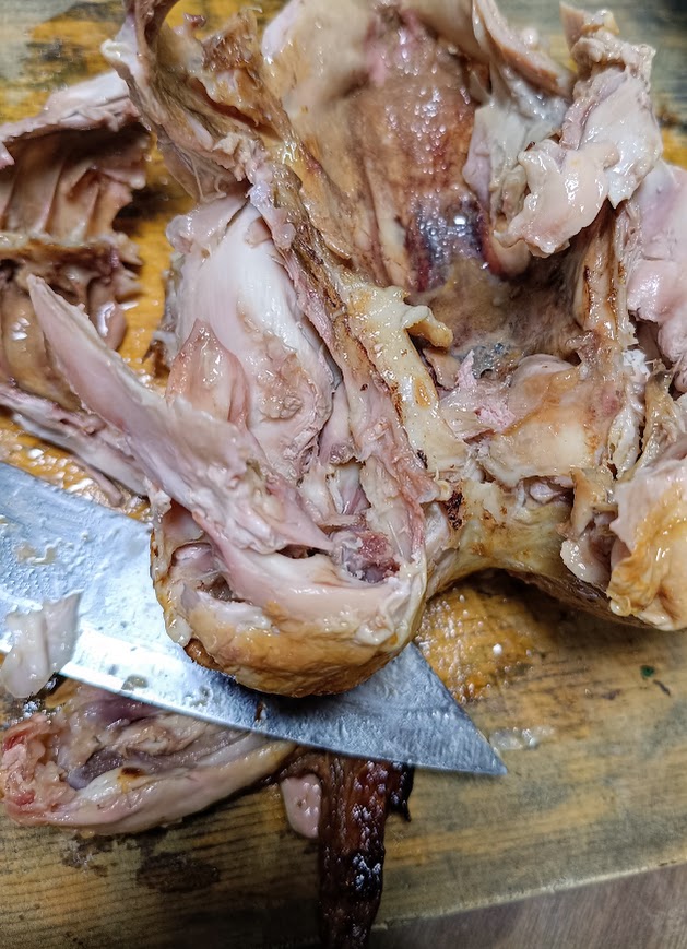 解体途中の丸鶏に包丁を当てている様子