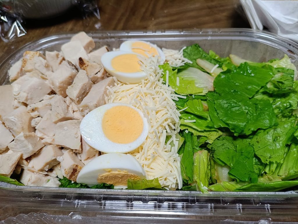 容器の中のグリルチキン・ゆで卵・チーズ・ロメインレタス