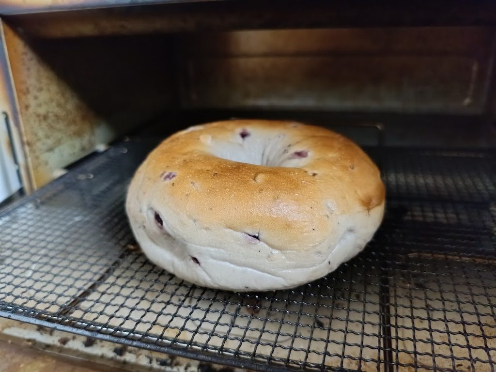トースターの網にのせたクランベリーブルーベリーベーグル
