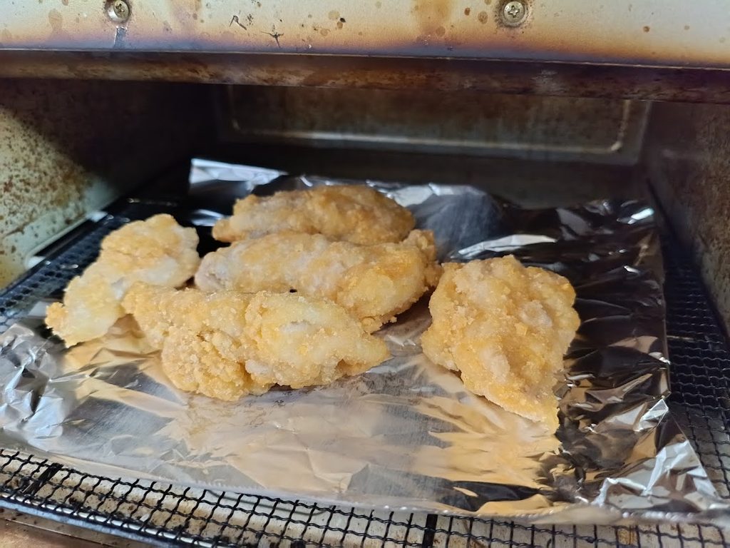 アルミホイルを敷いたトースターに並べたバックリブのフライドチキン(5本)