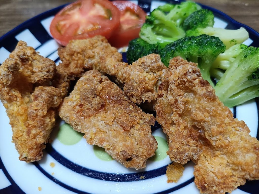 皿に盛ったバックリブのフライドチキンとトマト・ブロッコリー