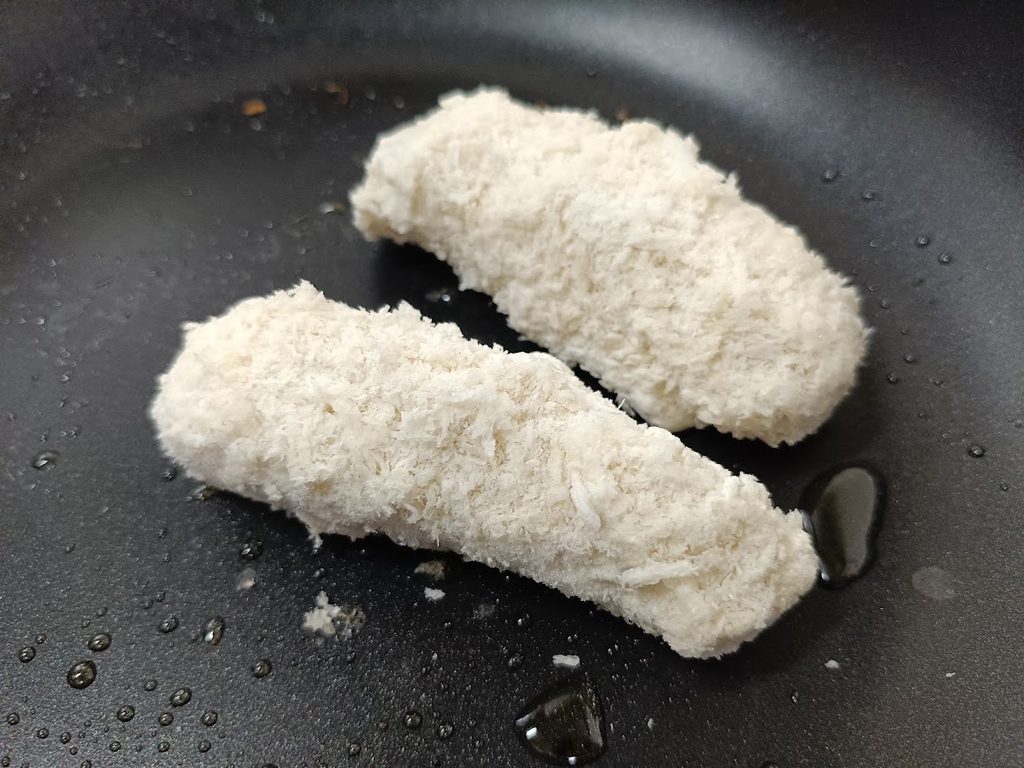 フライパンの油の上に置いた凍ったままのささみチーズフライ2本