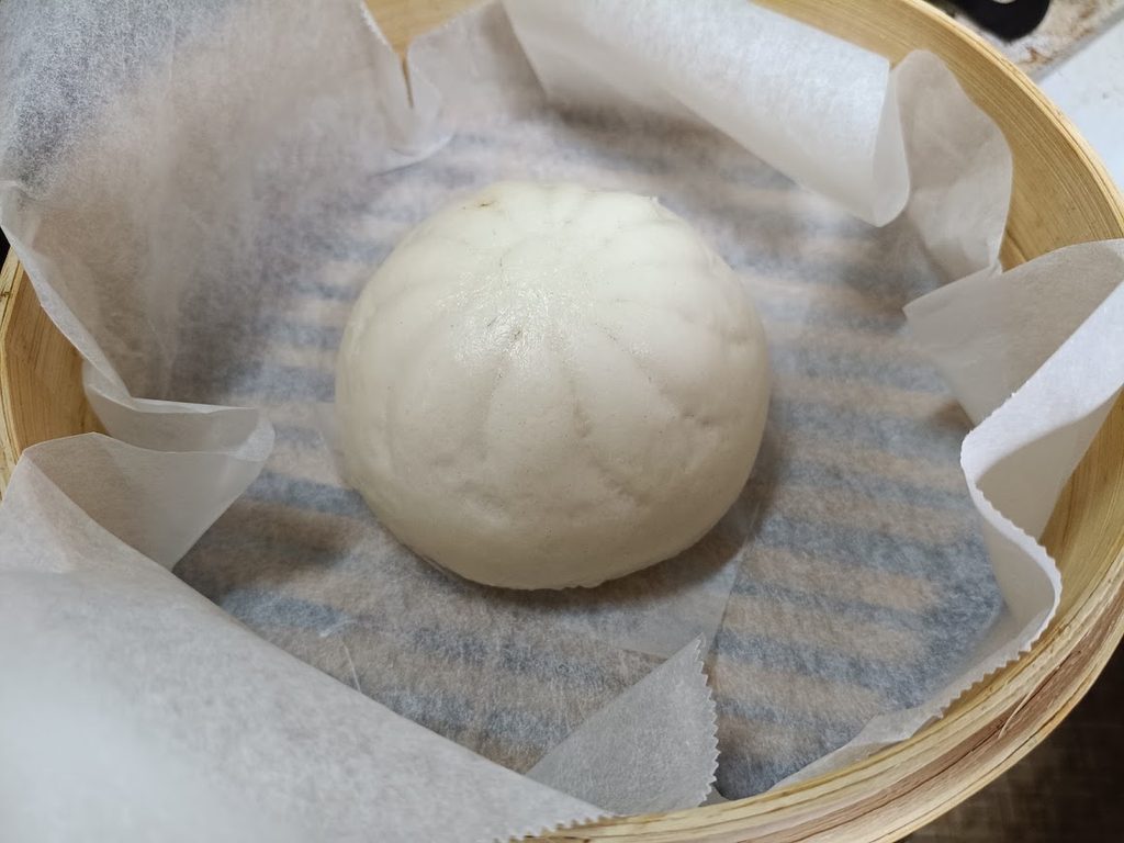 セイロに敷き紙を敷いて蒸した金の肉まん