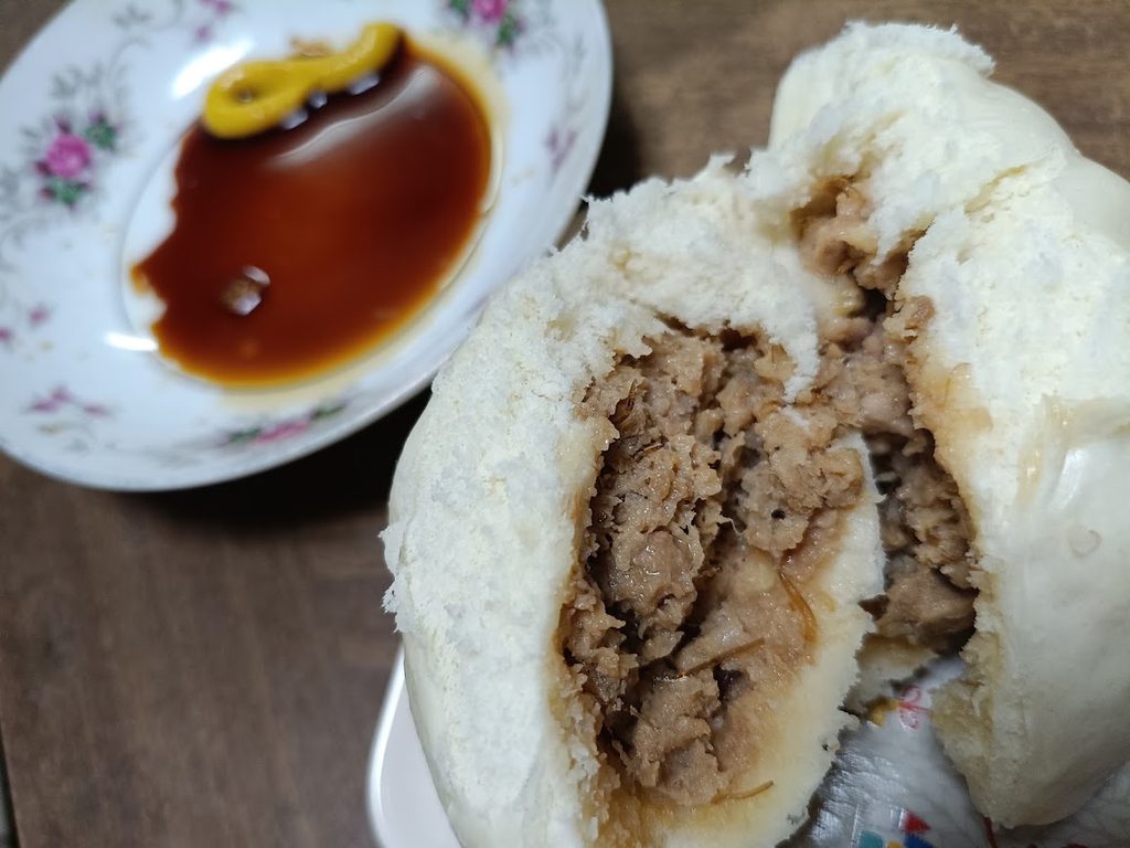 割った金の肉まんと、醤油とカラシを入れた小皿