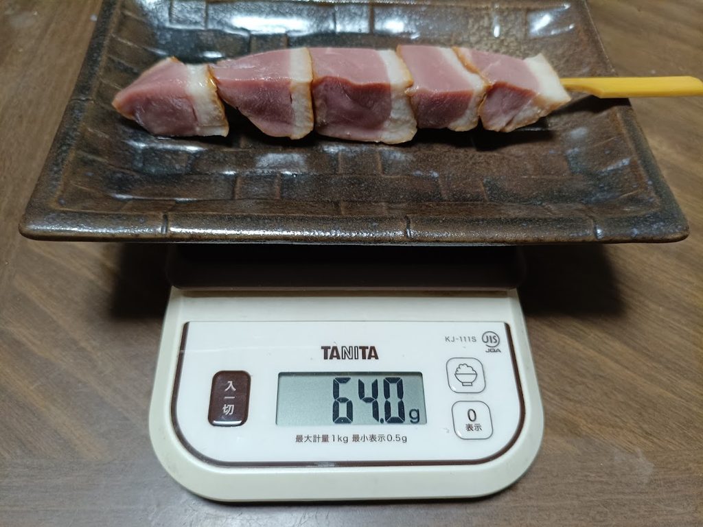 合鴨ステーキ串1本を、お皿ごとはかりに載せた様子(64.0g)