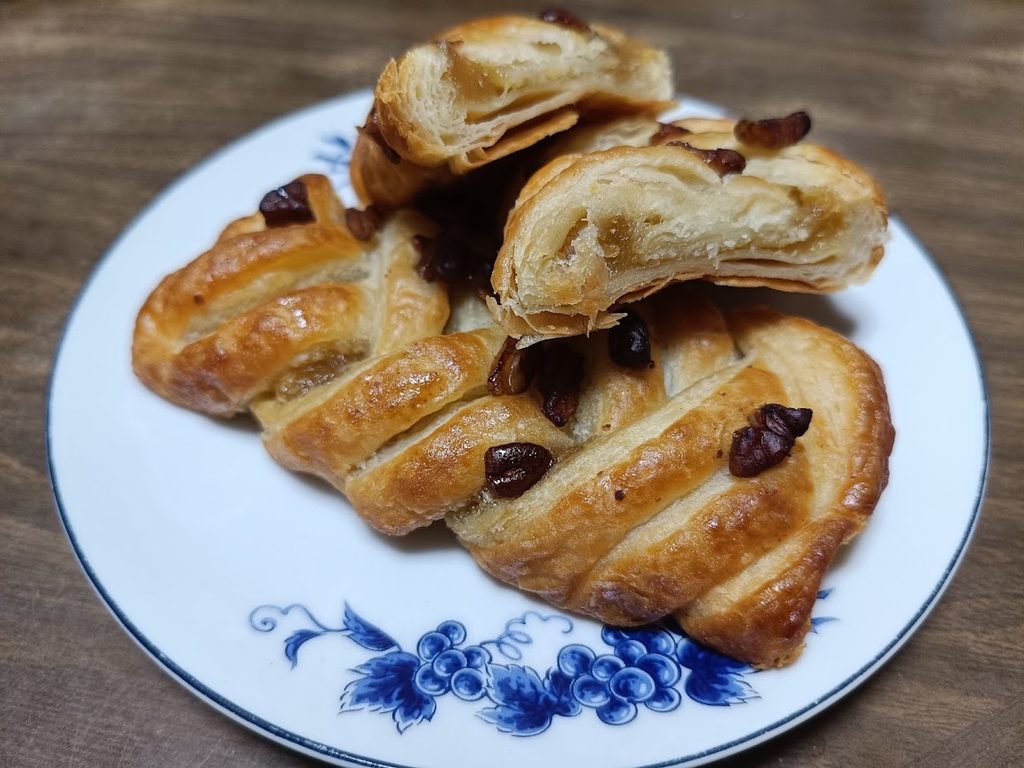 お皿にのせたメープルピーカンシュトルーデルと切り分けた断面