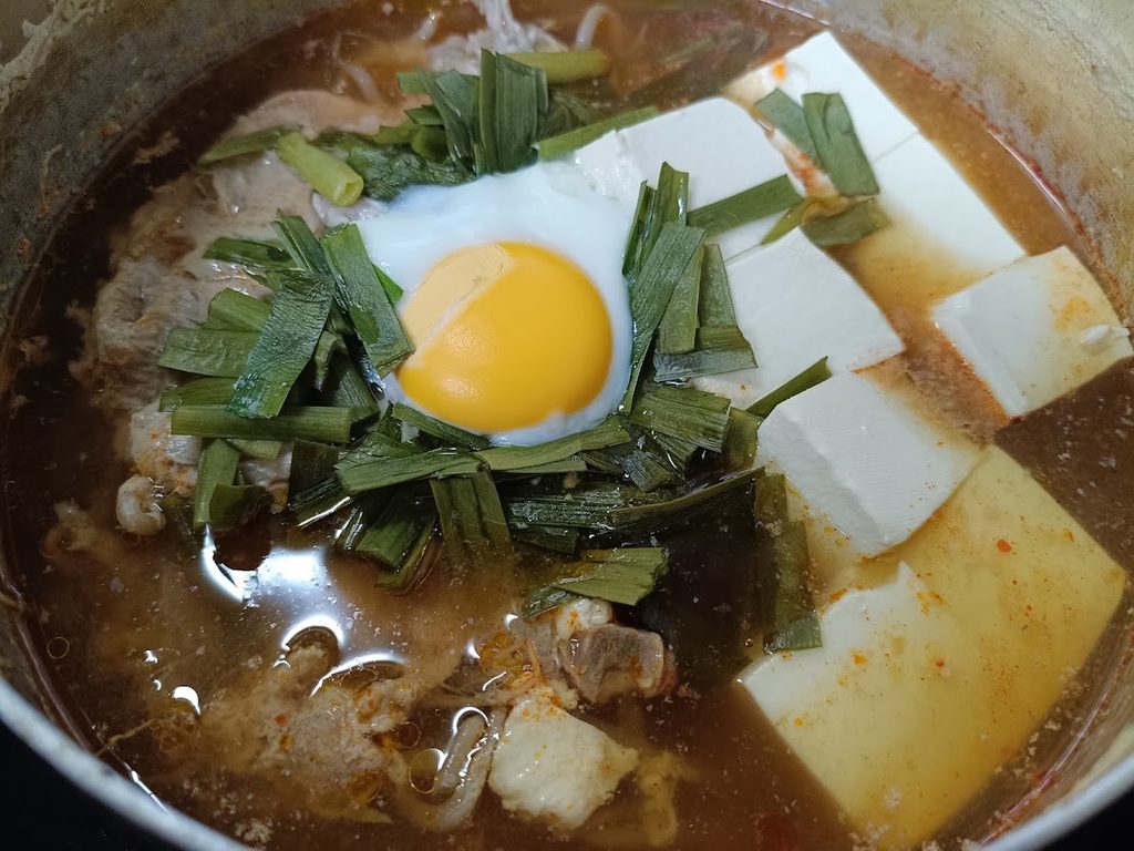 豚肉・もやし・豆腐・ニラ・玉子を入れた味噌にんにく鍋