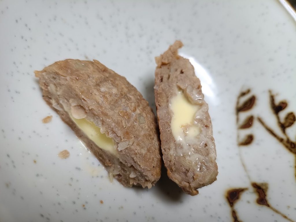 割ったハンバーグの断面。チーズソースが見える