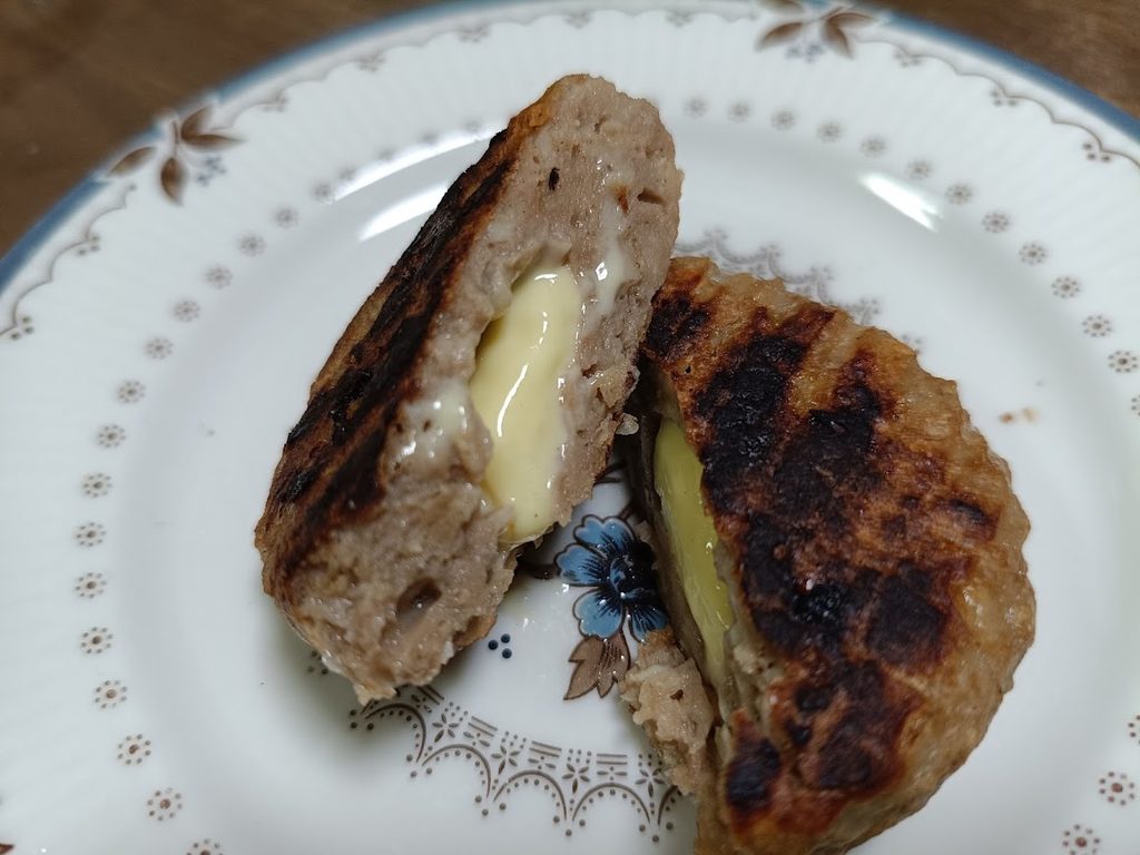 割ったハンバーグの断面。チーズソースが見える