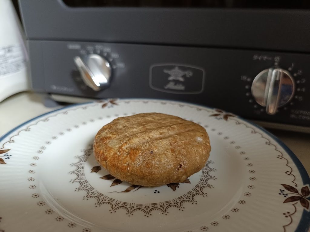 トースターの前の皿に乗せた、トースターで焼いたハンバーグ1個