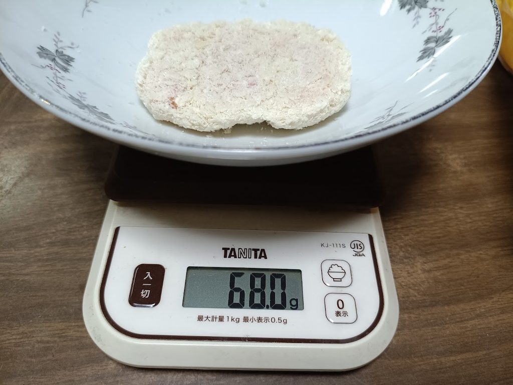 スケールで68.0gと表示された、皿の上のチキンカツ1枚