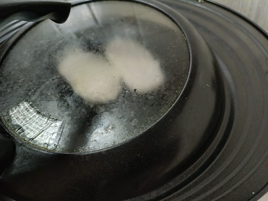 蓋をしたフライパンの中のチキンカツ2枚