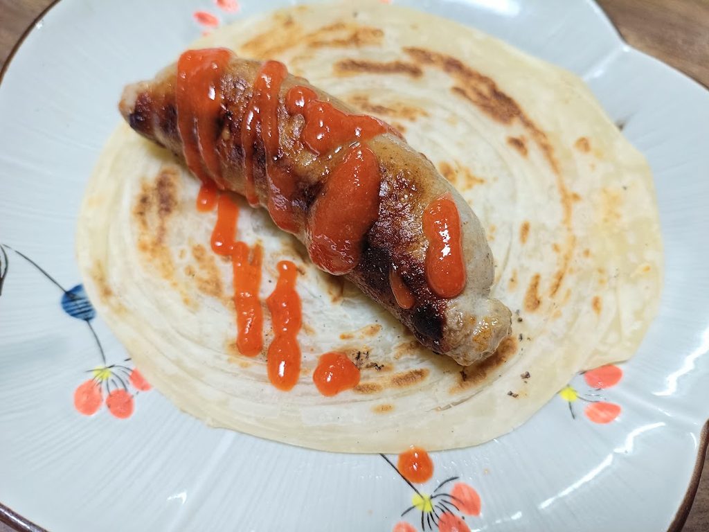 マラバルパラタに乗せてシラチャーソースをかけたフランク